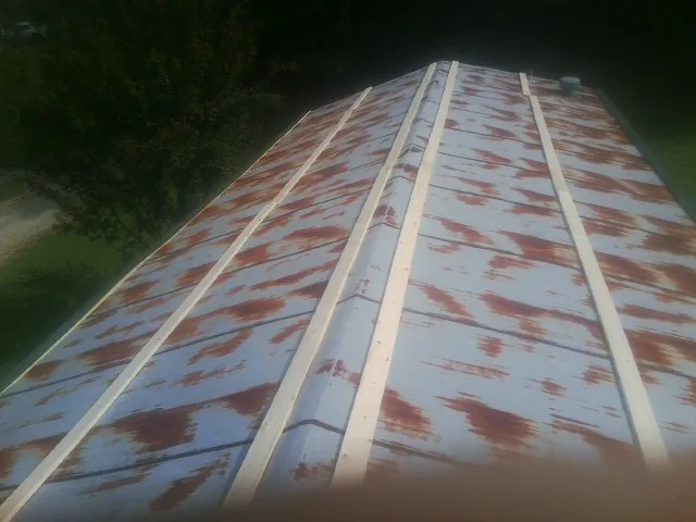Rusted metal roof panels with new wood purlins before replacement — Storm Damage Roof Repair in Kingsville by Roofing Brothers