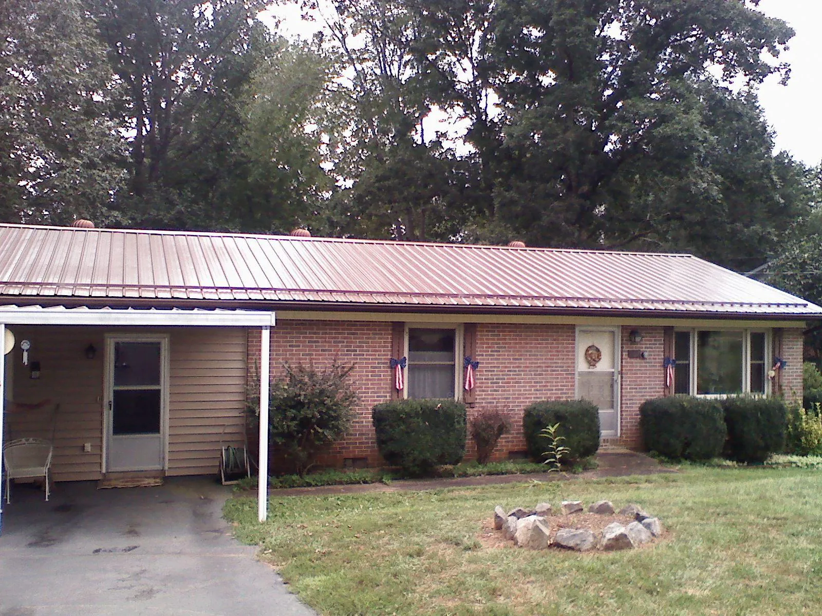 Bronze metal roof and carport on a brick ranch home — Roof Repair work by our crew in Kingsville